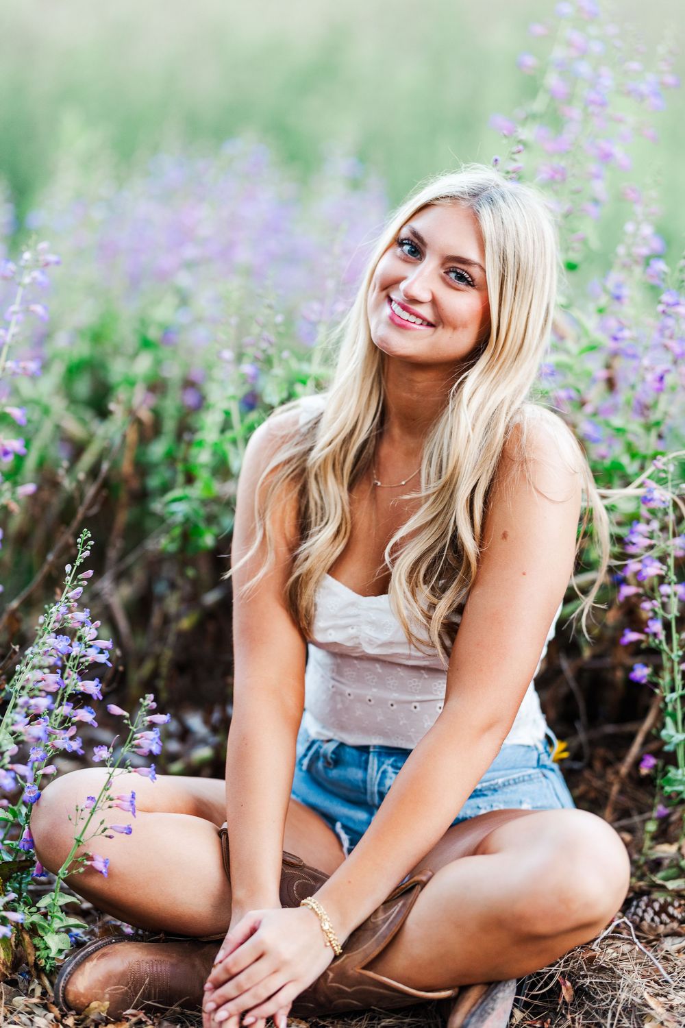A series of outdoor portrait photos showing a person sitting among blooming purple wildflowers in casual summer attire.
