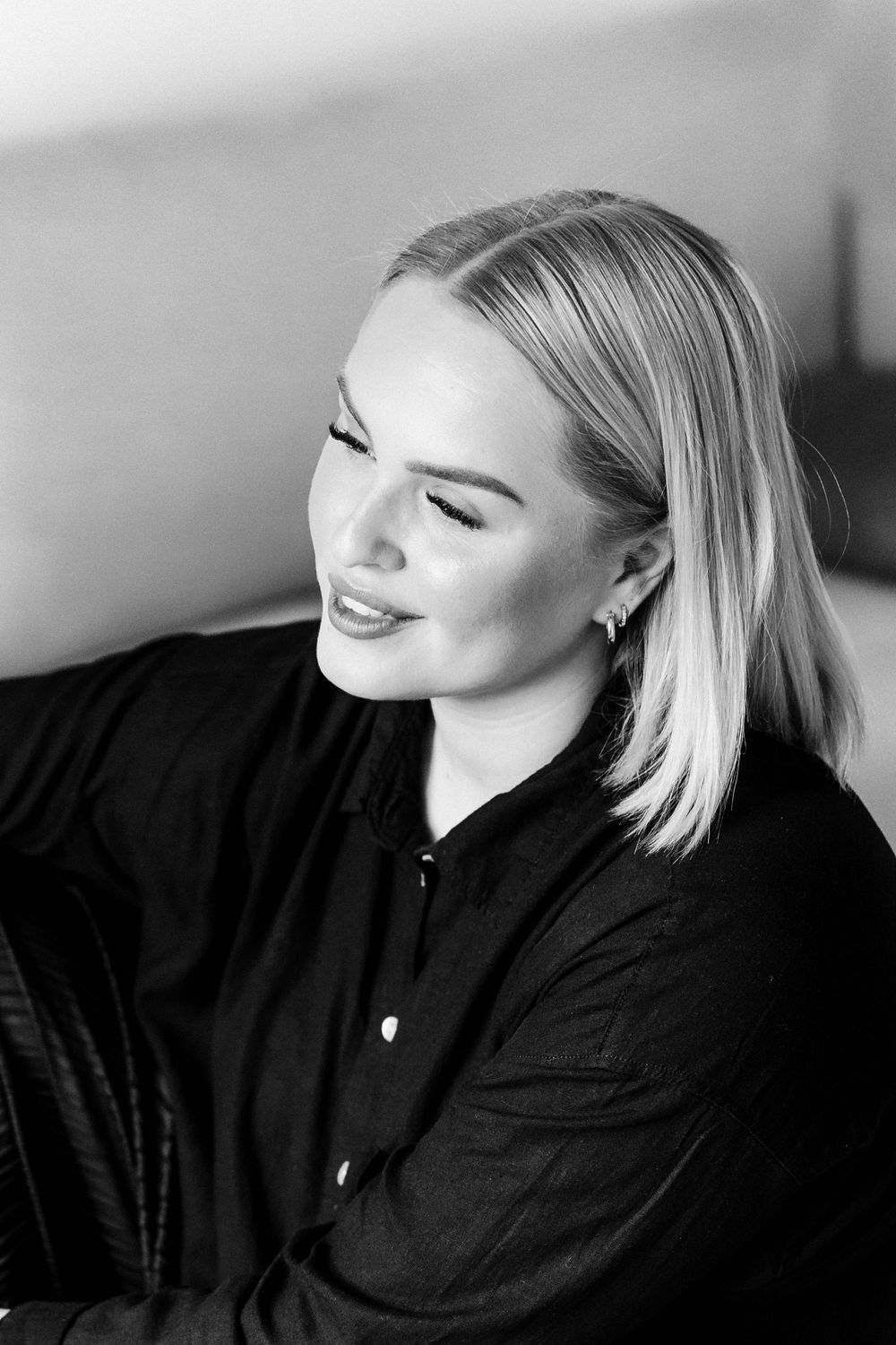 Black and white portrait series showing dramatic poses in a black top against a light background.