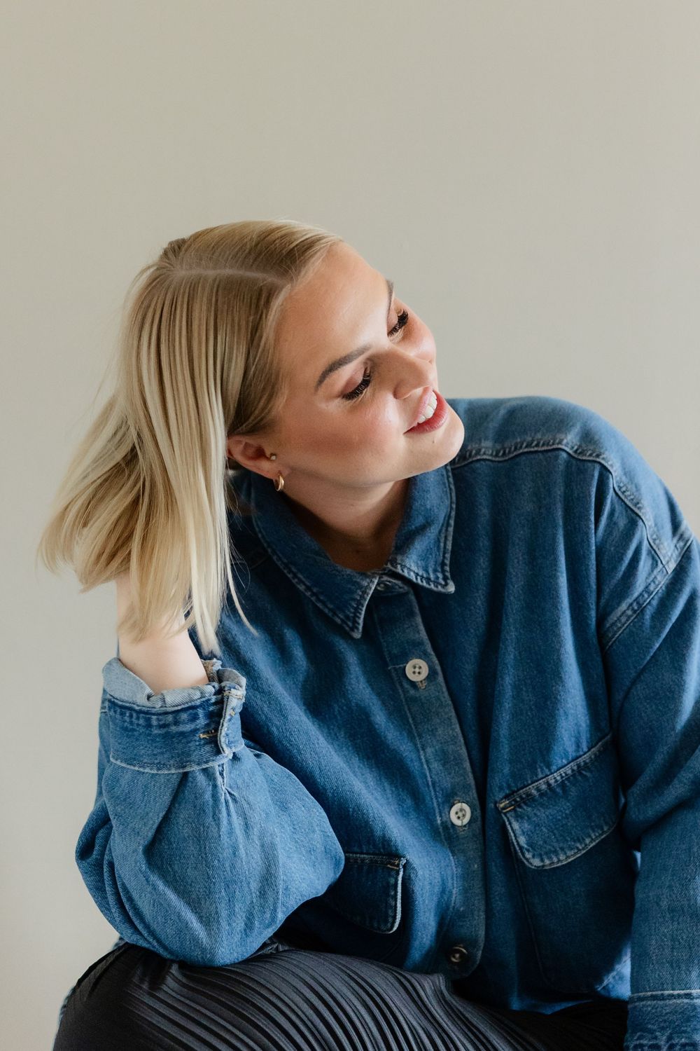 A person wearing a denim jacket poses against a light background in a series of expressive shots.