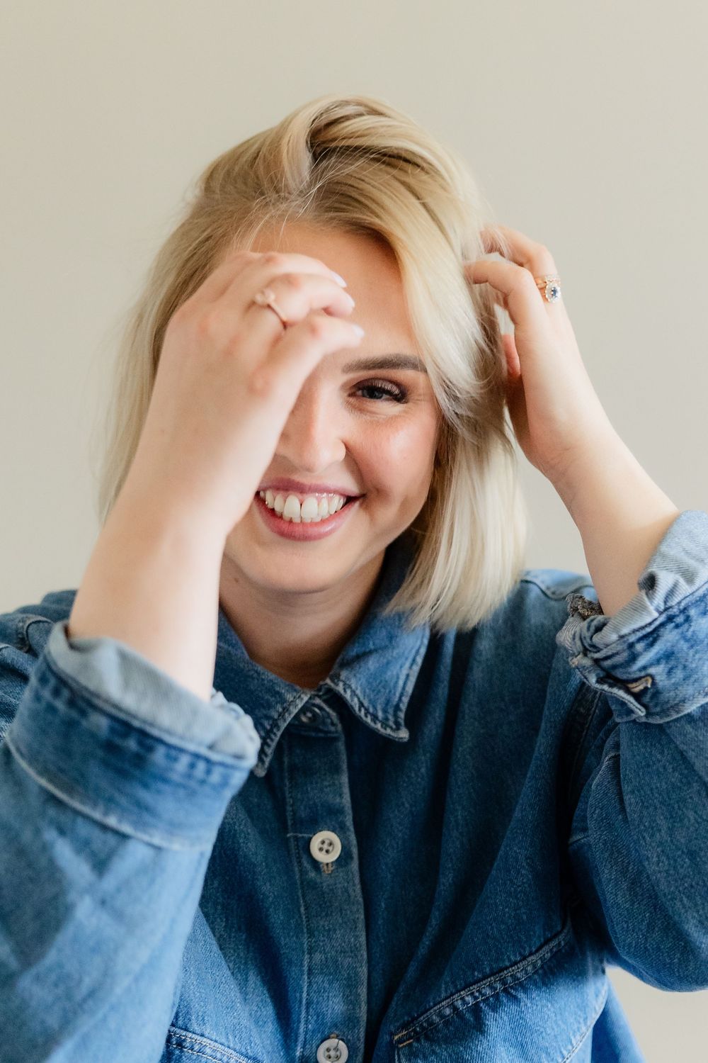 A person in denim laughs joyfully while covering their face with their hands in a series of candid expressions.