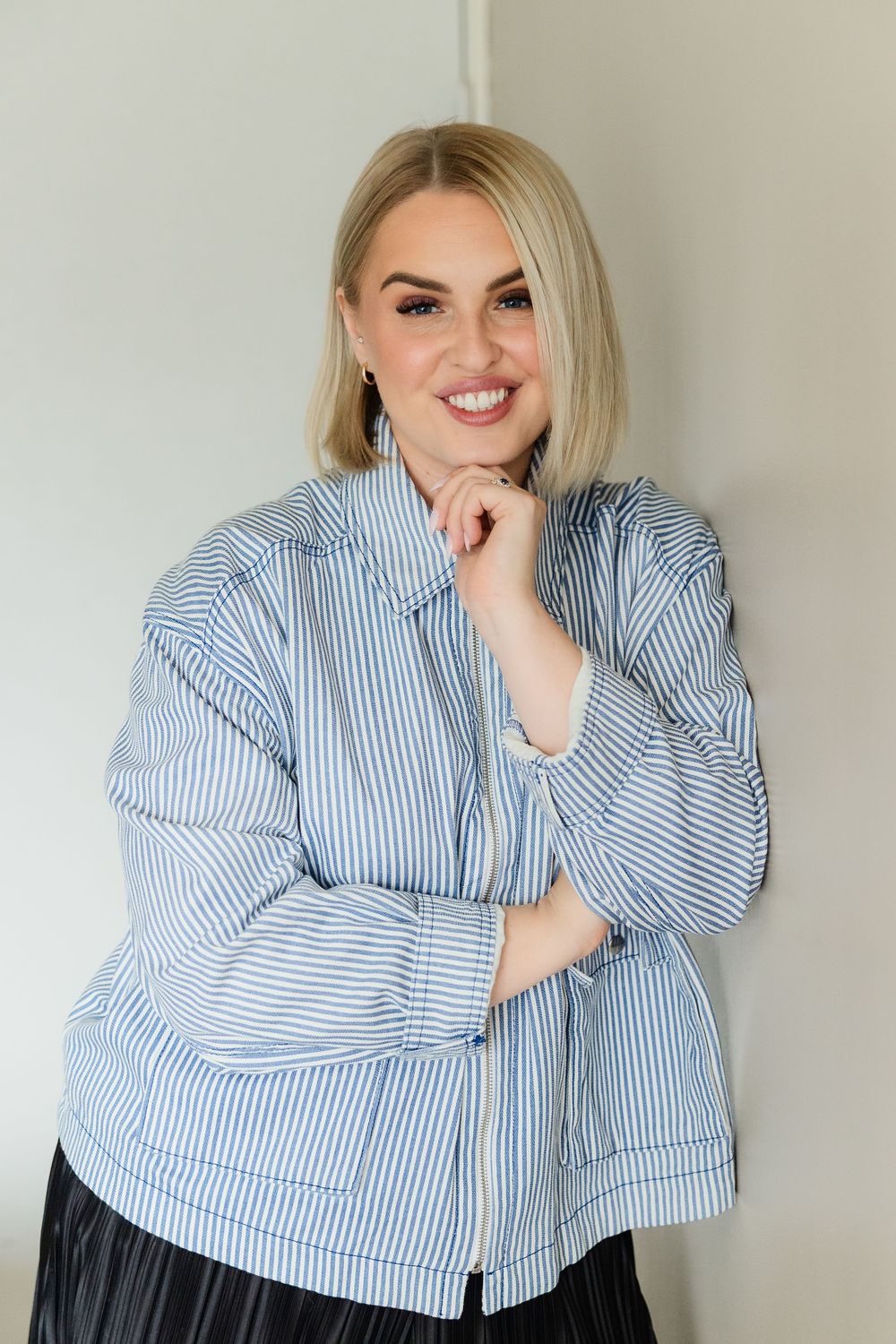 Four poses of someone wearing a blue and white striped button-down shirt against a light background.