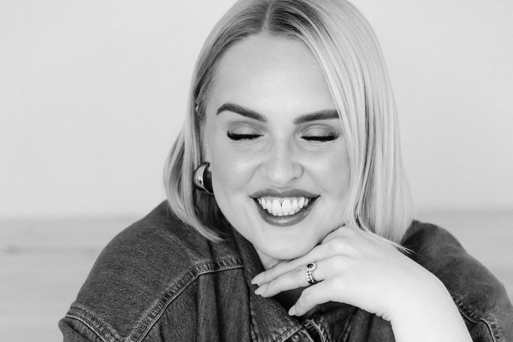 A series of black and white photos showing a person laughing and smiling in various candid expressions.