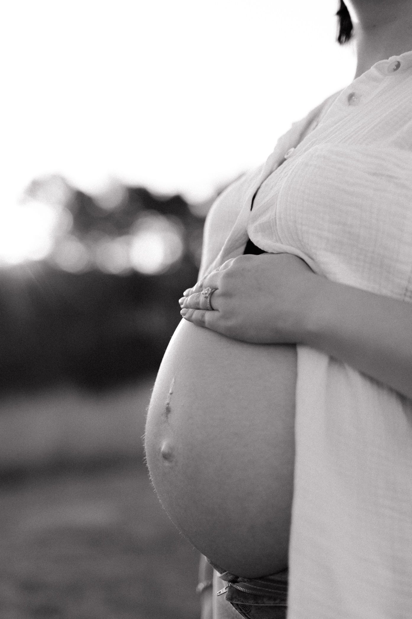 A black and white photo series showing a pregnant belly at different stages of pregnancy growth.