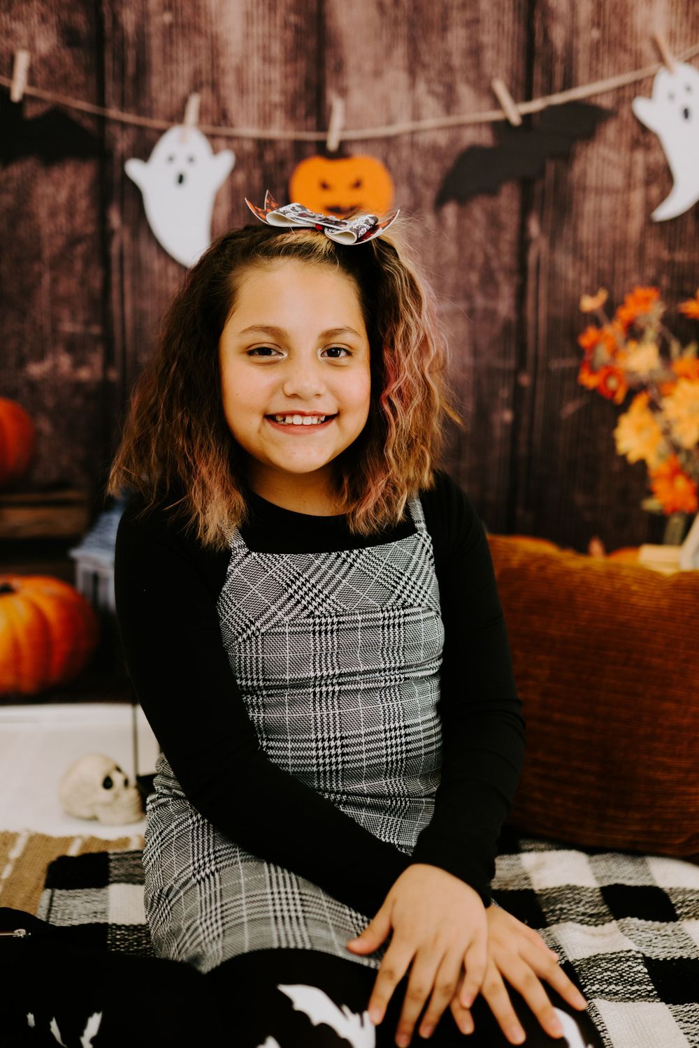 An autumn-themed portrait with Halloween decorations and rustic wooden background.