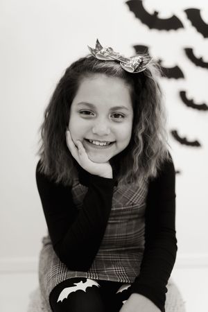 Black and white portrait with Halloween bat decorations in background.