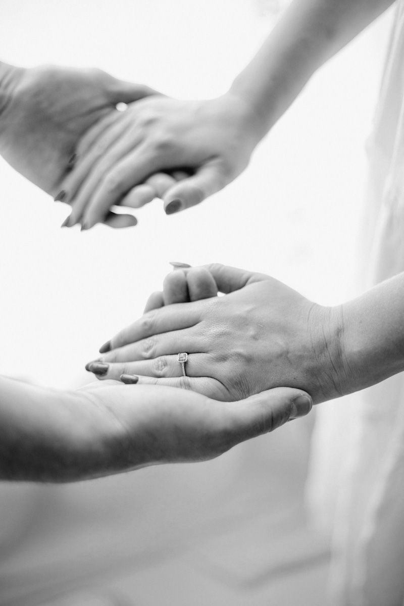 Black and white images of hands showing a sequence of gentle touching movements against a light background.