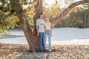 Broer en zus tijdens een golden hour fotoshoot op de zandvlakte in Ommen, Overijssel.