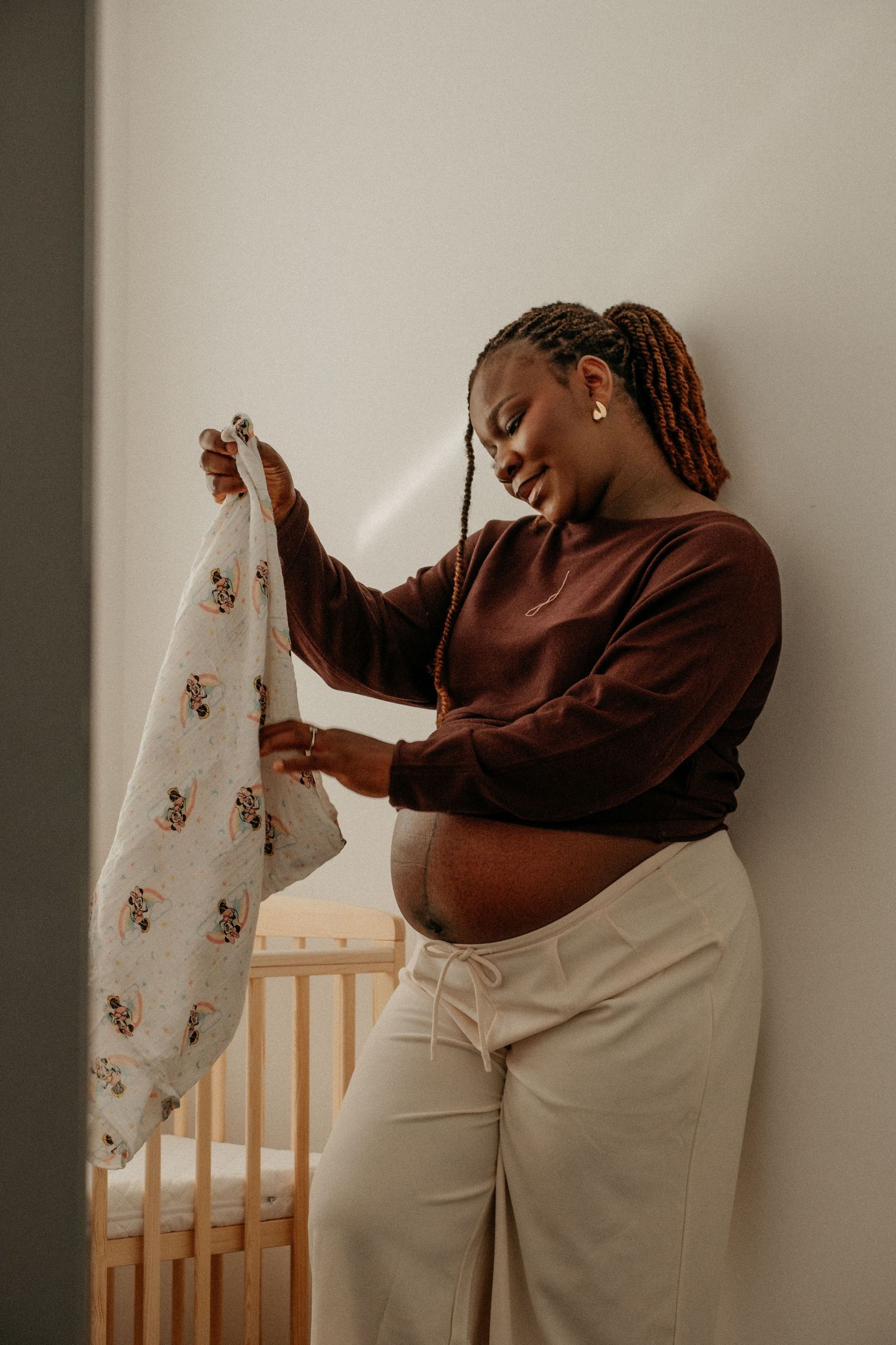 A pregnant mom folding a blanket