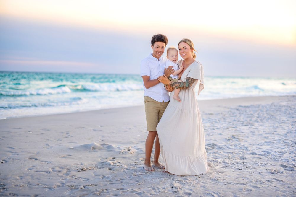 A couple shares a romantic moment on a pristine white sand beach at sunset.