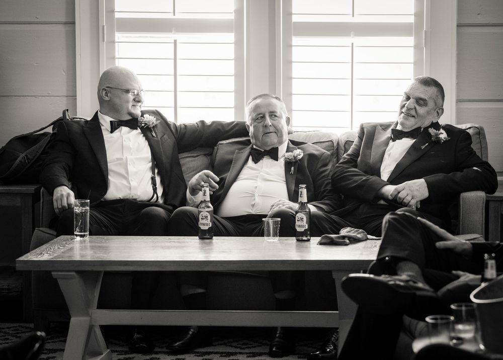 Black and white series of candid moments showing relaxed poses on elegant furniture in a bright room.