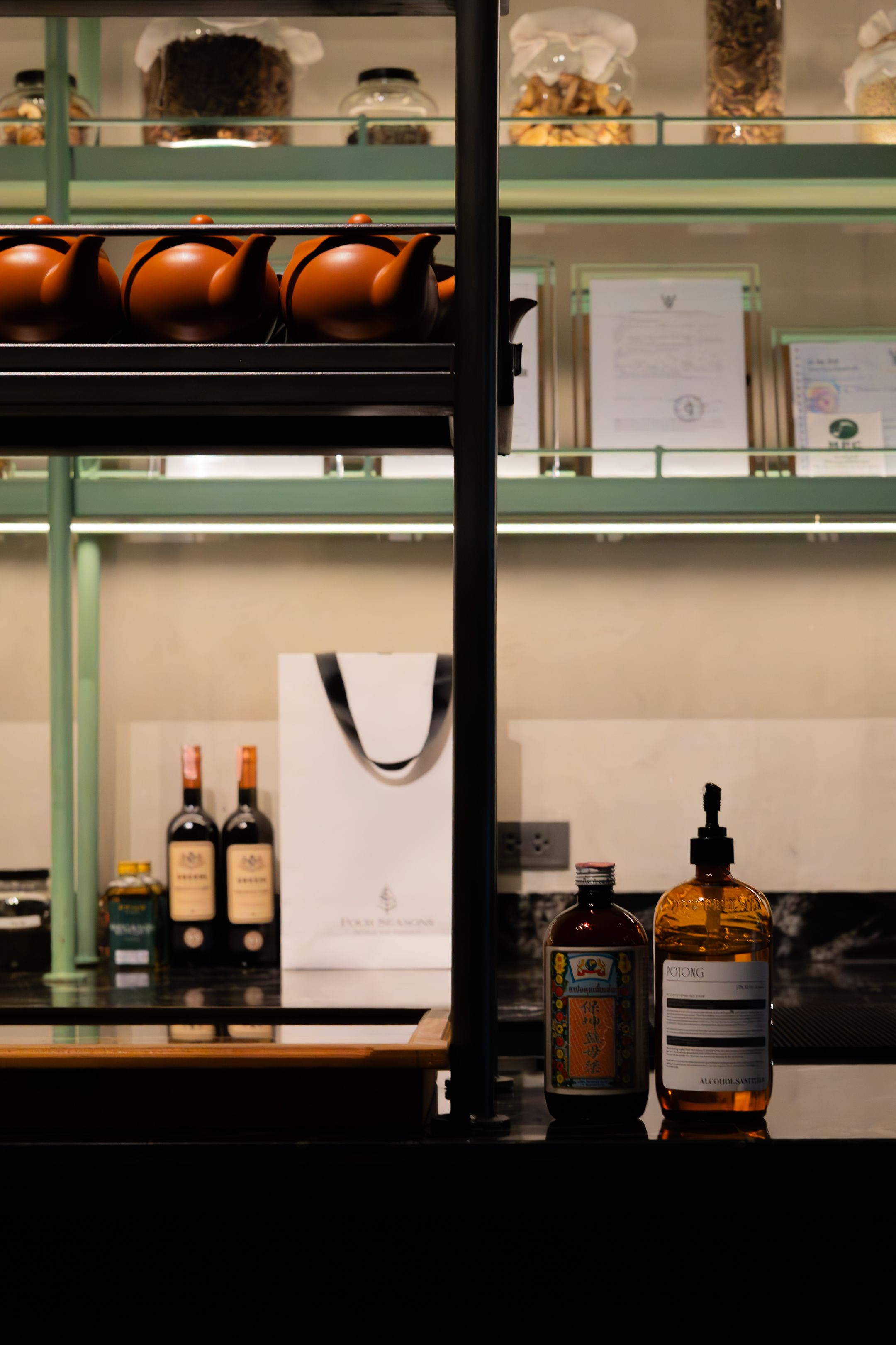 Dimly lit bar shelf with silhouettes of premium liquor bottles against backlighting.