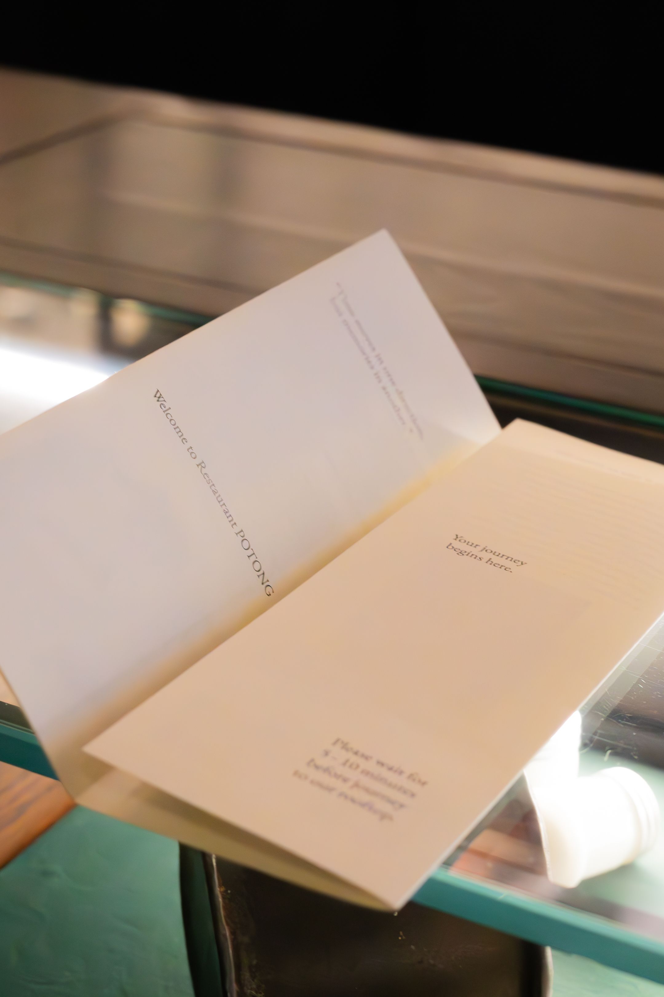 White paper documents arranged in a sequence on a reflective surface with green accents.
