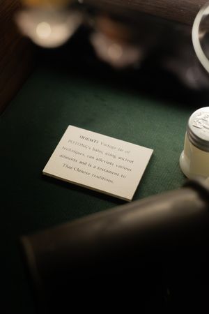 Close-up view of elegant menu cards with text on a dark green surface.