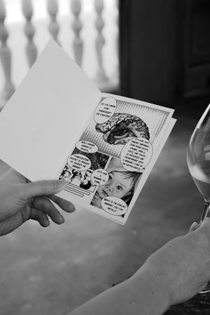 Black and white comic strip panels being held and displayed in sequence.