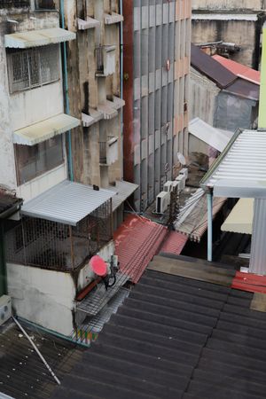 Aerial view of residential buildings with metal roofs and awnings in an urban setting.