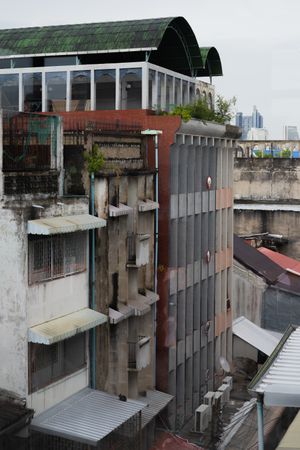 Urban rooftop view showing industrial buildings with metal awnings and concrete structures.