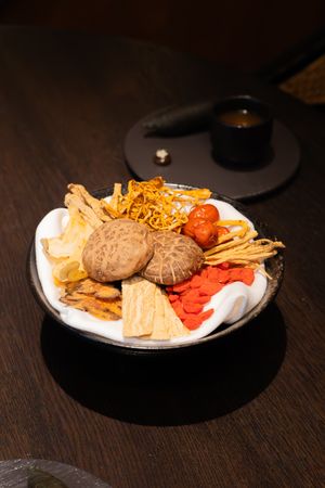Plate of appetizers with french fries, sliders, and crispy garnishes served on white dinnerware.