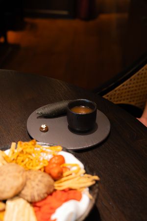 Dark wooden table with plated food and a black circular serving dish.