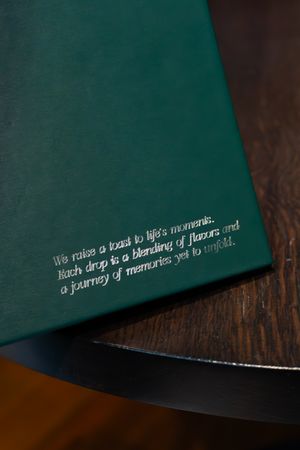 Inspirational quote printed in silver text on dark green textured surface.
