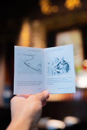 A small illustrated storybook being held open to show sequential narrative panels.