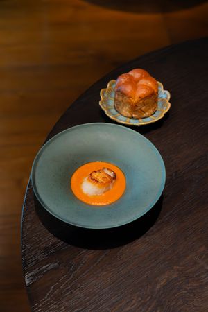 Orange-colored gourmet dish presented on gray ceramic plate.