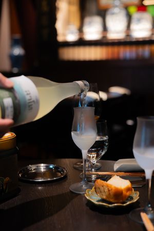 Wine glasses and table settings in a dimly lit upscale restaurant atmosphere.