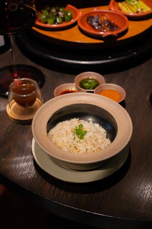 Bowl of steamed rice garnished with herbs served in modern ceramic dishware.