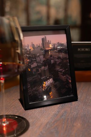 Cityscape photographs displayed on wooden table with ambient lighting.
