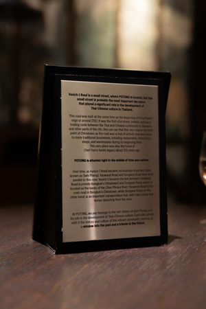 A black-framed menu or text display stands on a dark wooden table in moody lighting.