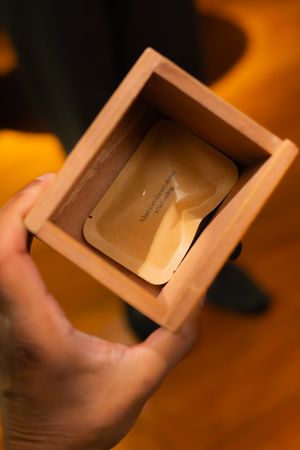 Wooden box being opened in warm ambient lighting showing contents inside.