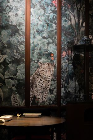 Decorative wallpaper featuring a leopard print design in muted blue and gray tones.