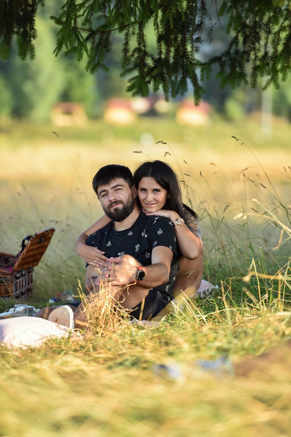 Couple relaxing together in tall grass on a sunny summer afternoon.