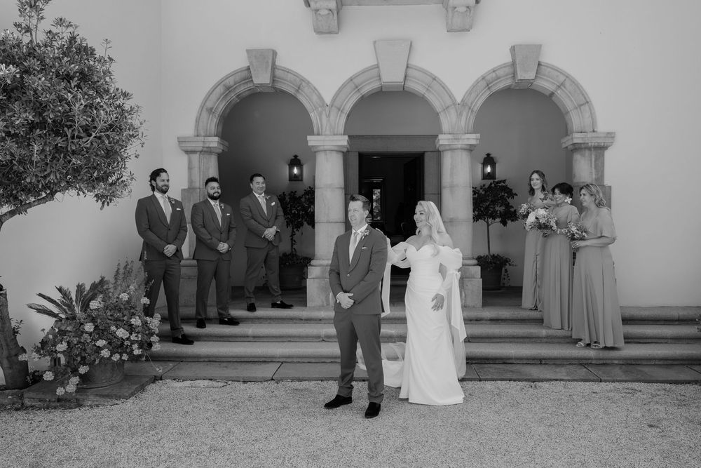A series of black and white wedding photographs showing couples and groups outside a historic Spanish-style church building.