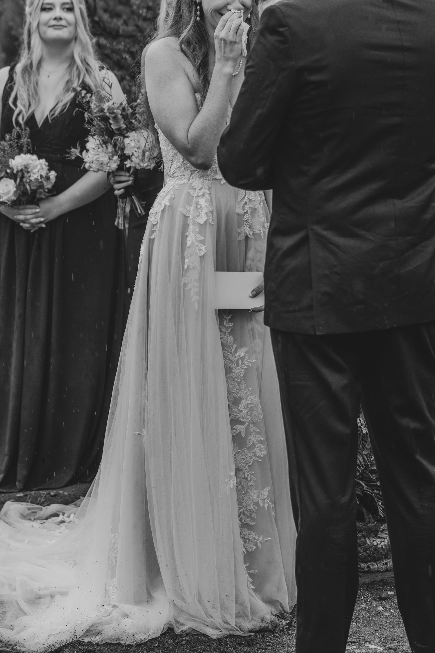 A wedding ceremony in progress with attendees in formal attire gathered outdoors.