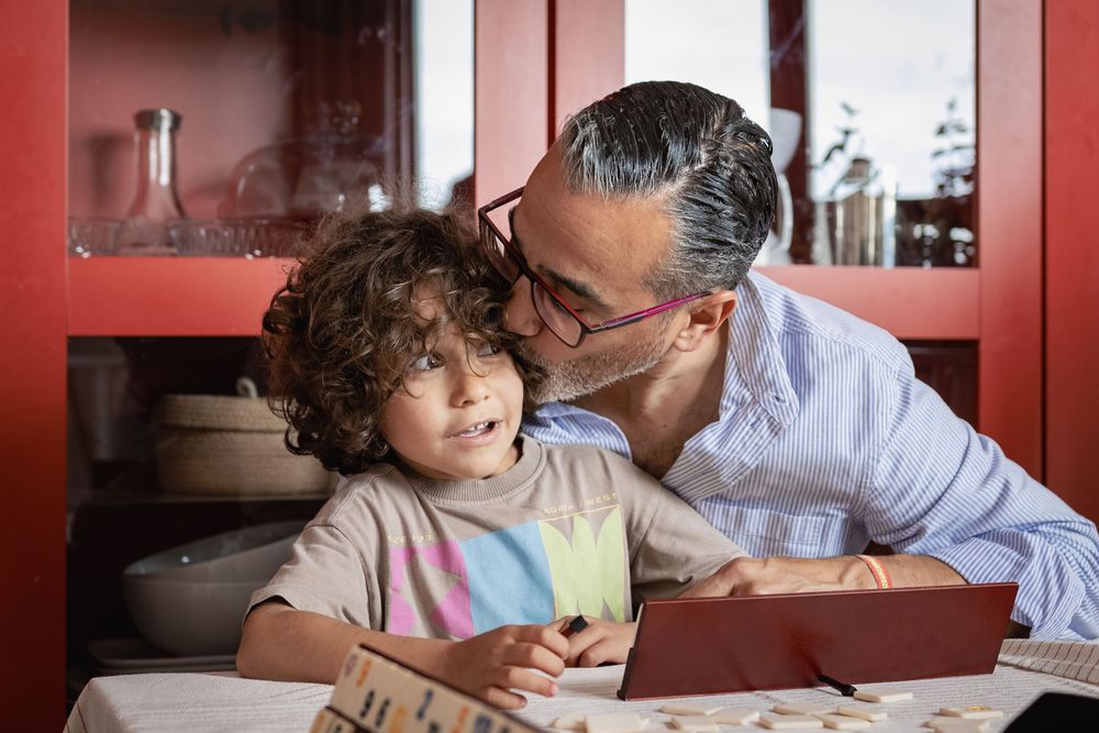 A collection of four heartwarming images showing tender moments between a parent and child reading together.