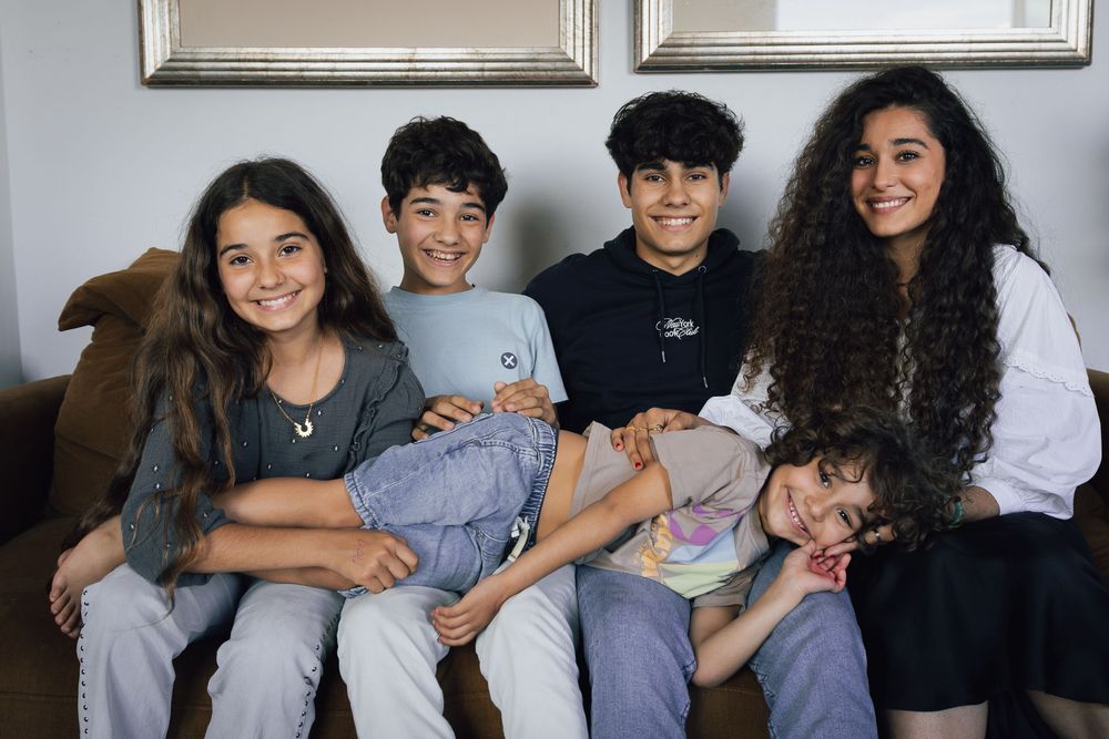 A group of people sitting together and smiling while posing for a casual photo.