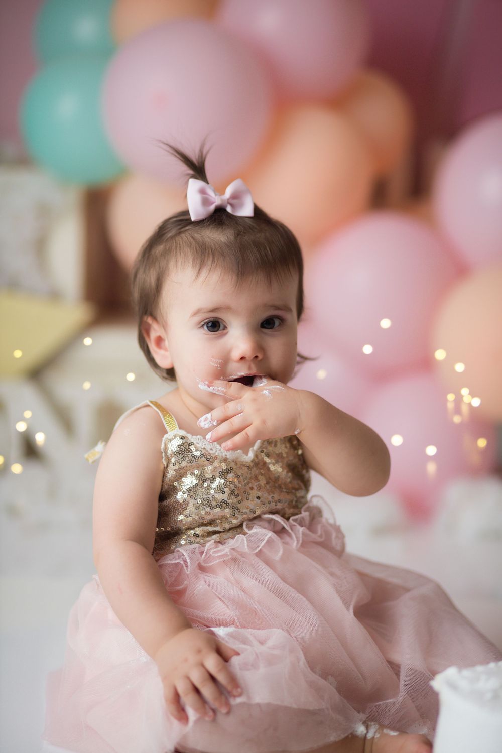 Dreamy pink birthday setup with twinkling lights and pastel balloon backdrop.