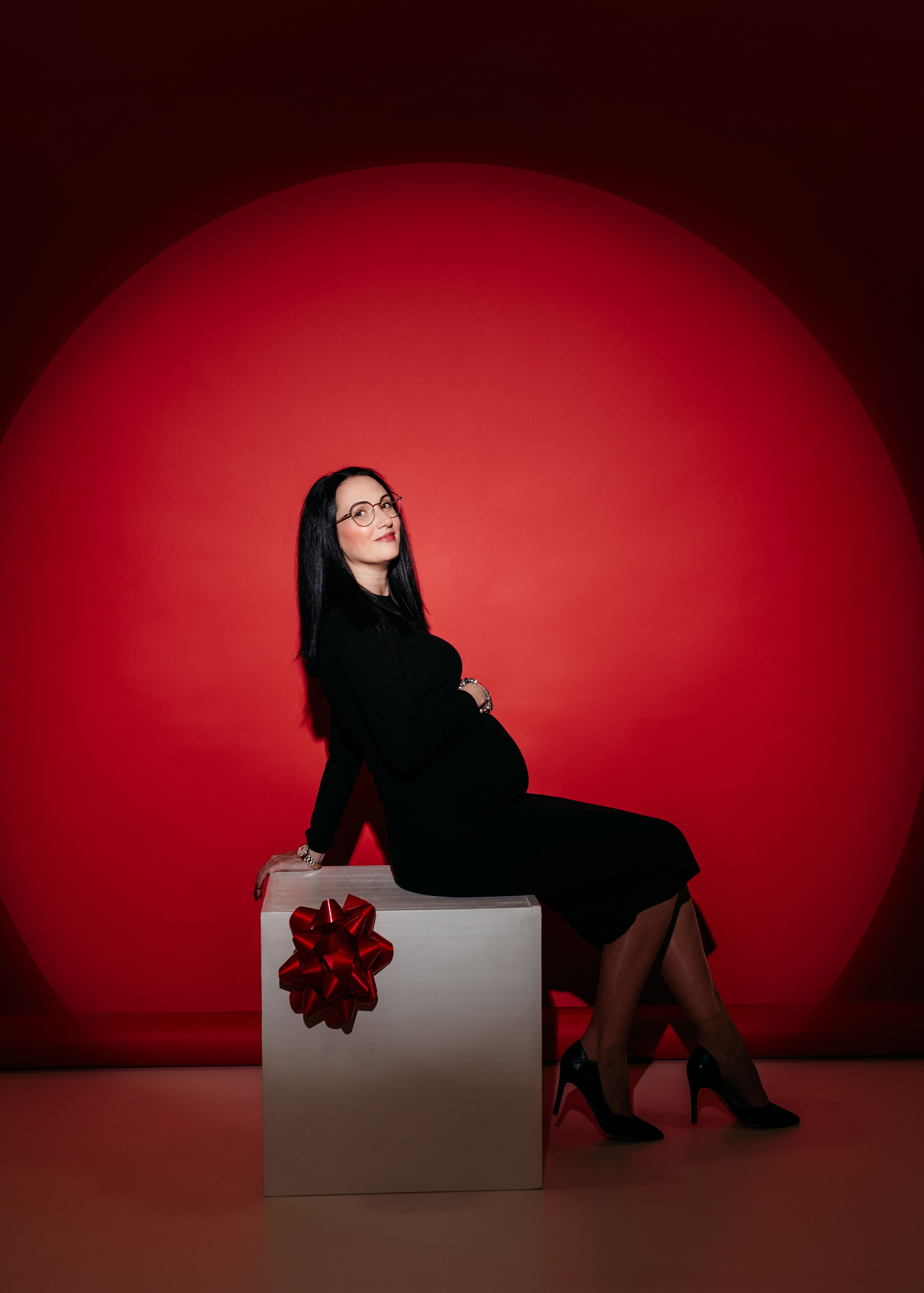 A silhouetted figure in black poses dramatically against a red backdrop in a sequence of artistic boudoir photos.