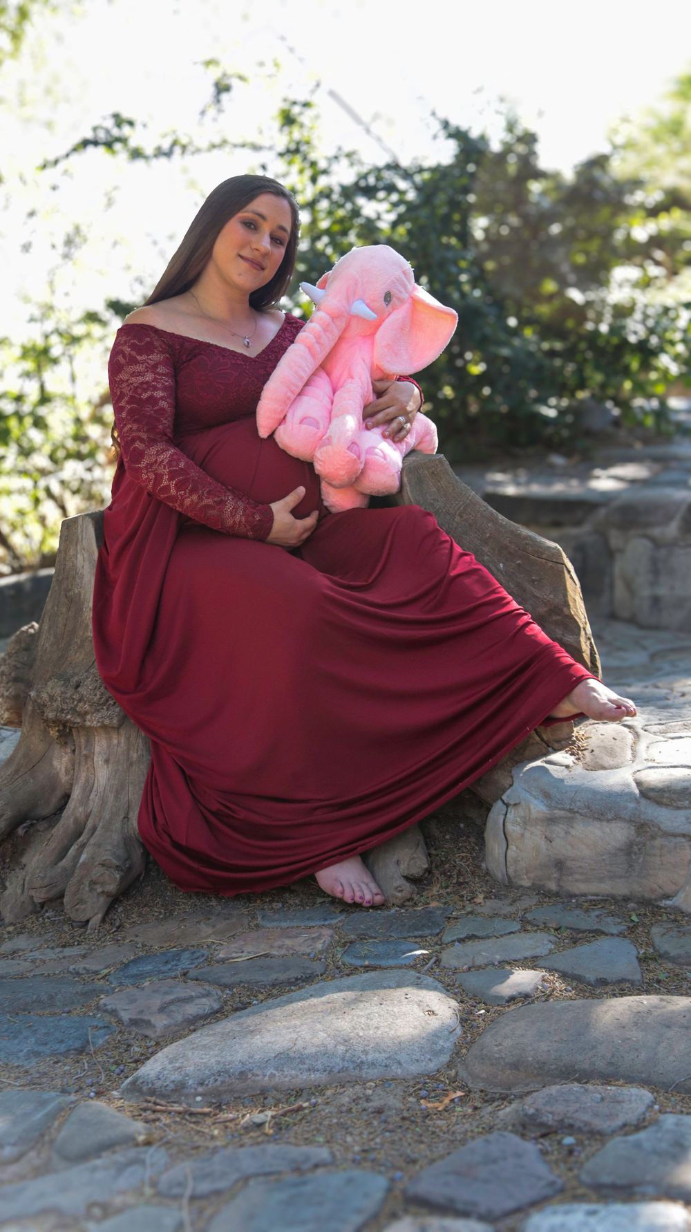 Pregnant woman posing in a red dress during an outdoor maternity photography session in Utah