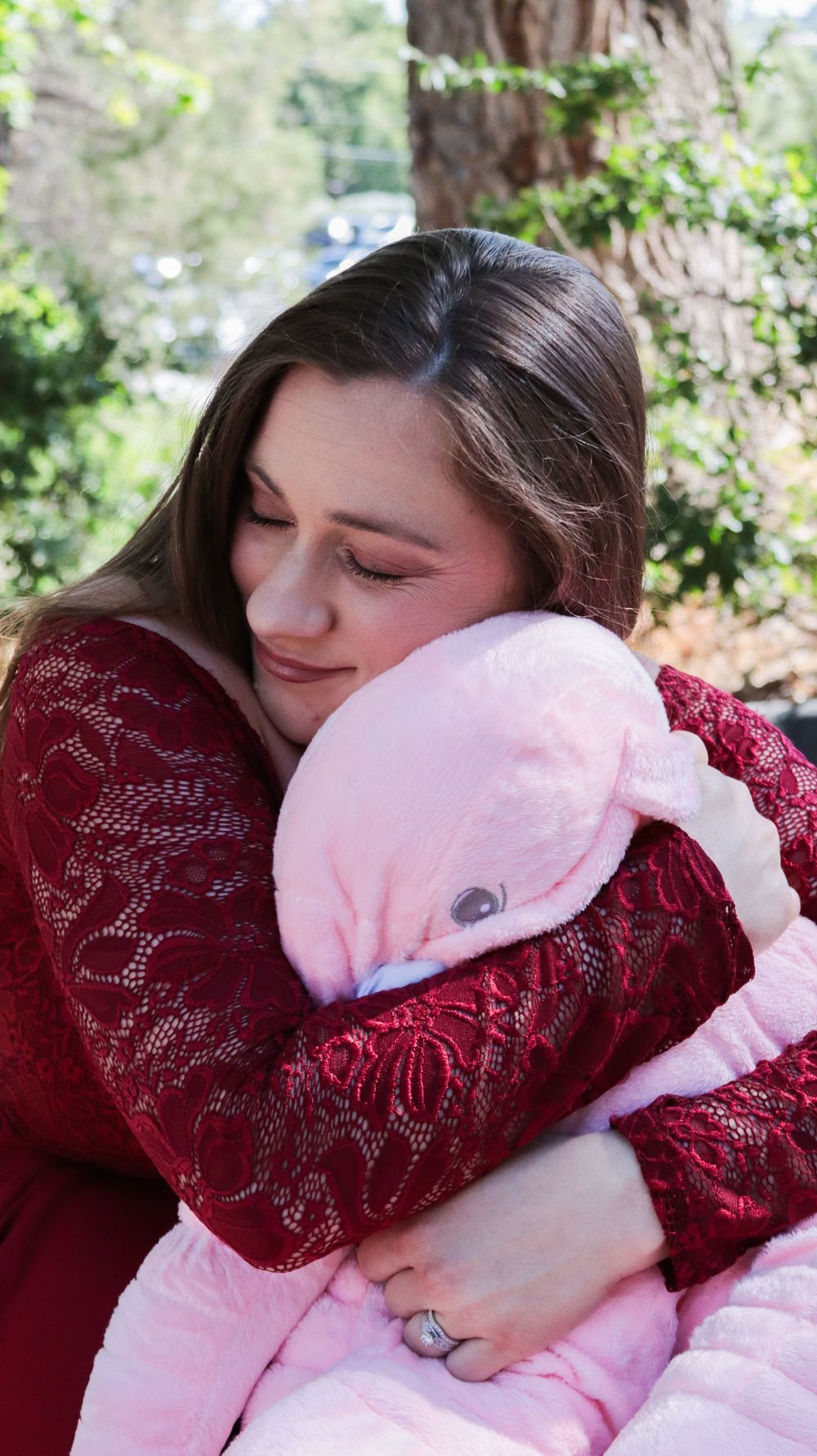 Mother embracing an elephant plush representing infant loss in a tender, reflective moment