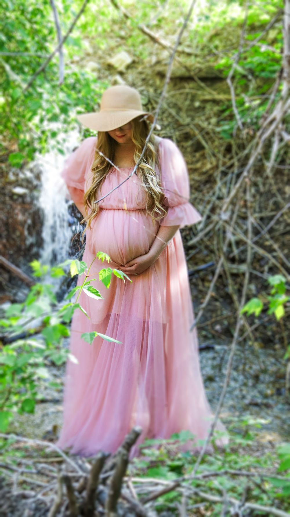 Pregnant woman standing outdoors in a flowing dress during a natural maternity session in Utah