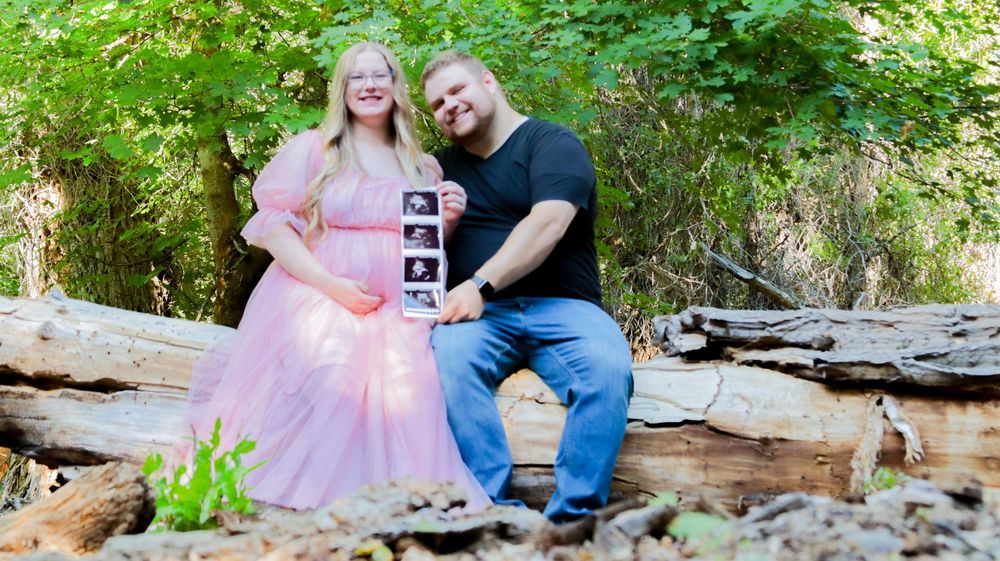 Couple holding ultrasound photo during an outdoor maternity session in Utah
