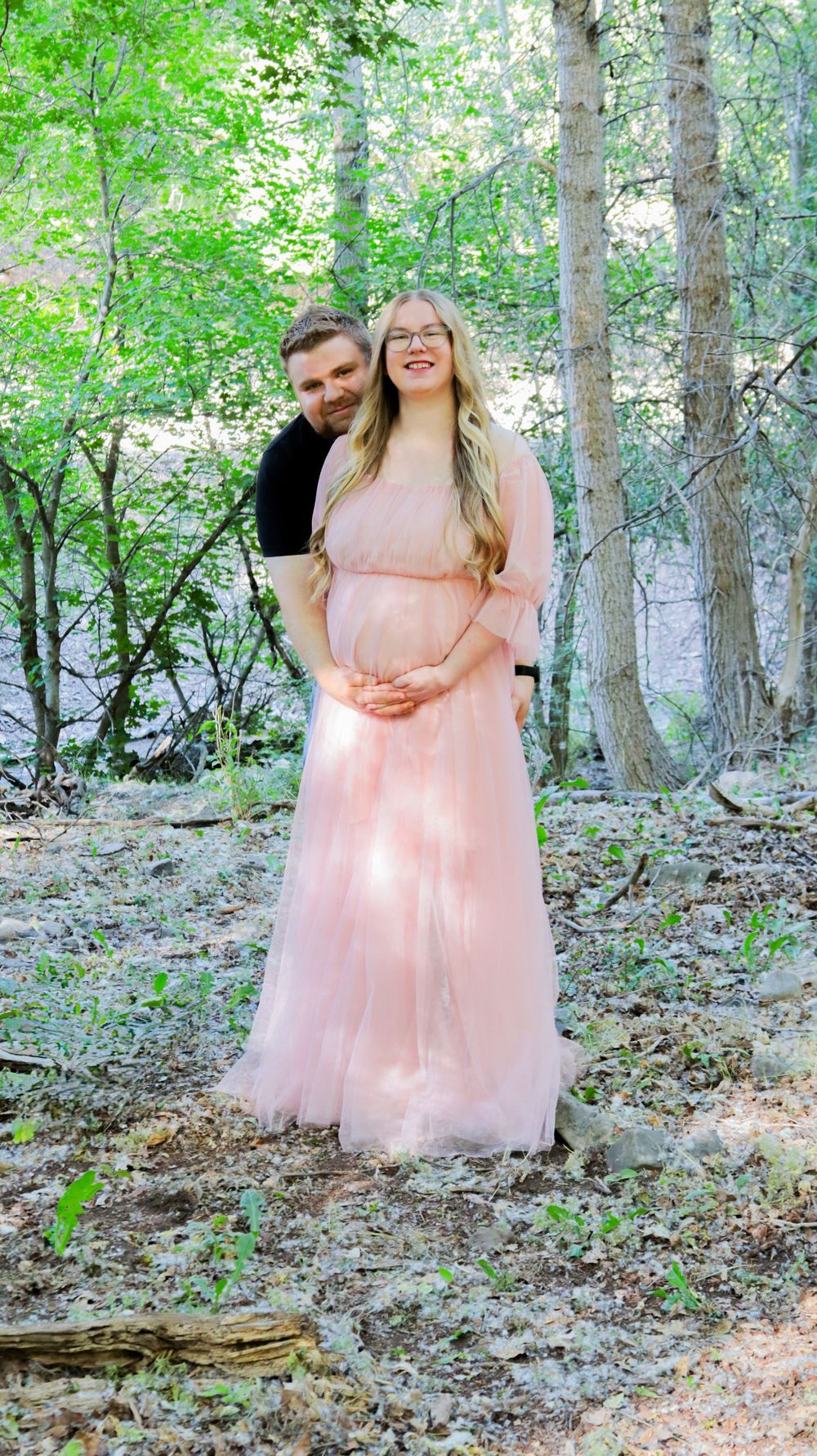 Pregnant woman standing in a wooded area during a maternity photo session in Utah
