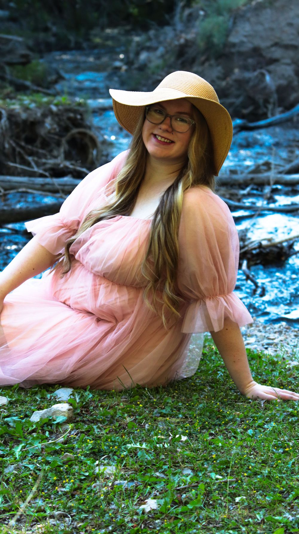 Pregnant woman sitting outdoors during a natural light maternity photography session in Utah
