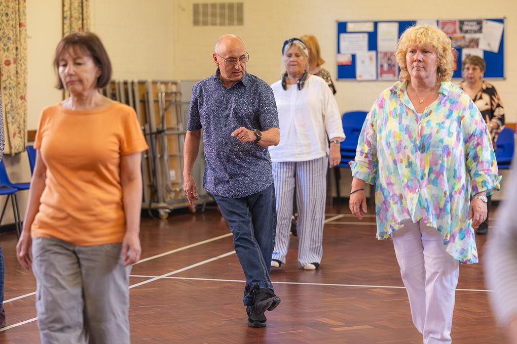 Active seniors participate in a line dancing class at a Letchworth community centre.
