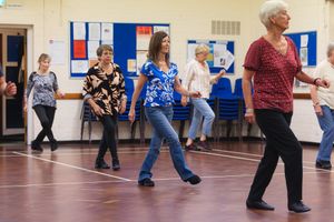 Active seniors participate in a line dancing class at a community centre in Letchworth.