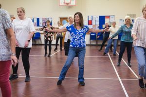 Line dancers move in formation on a gymnasium floor during a dance class in Letchworth.