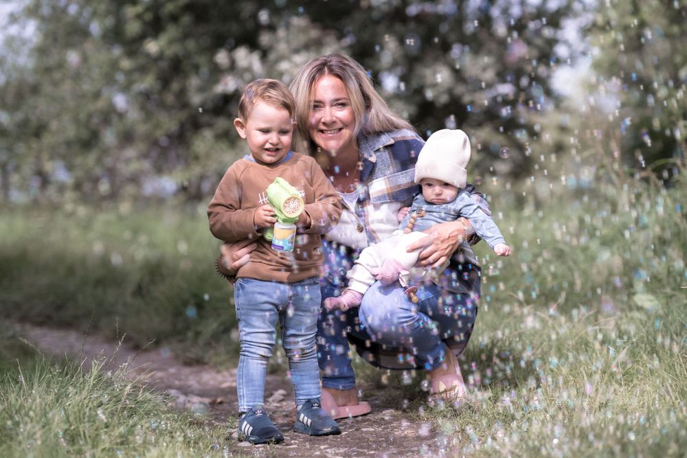 Ein fröhlicher Moment im Freien auf einer Wildblumenwiese mit Kindern an einem sonnigen Tag.