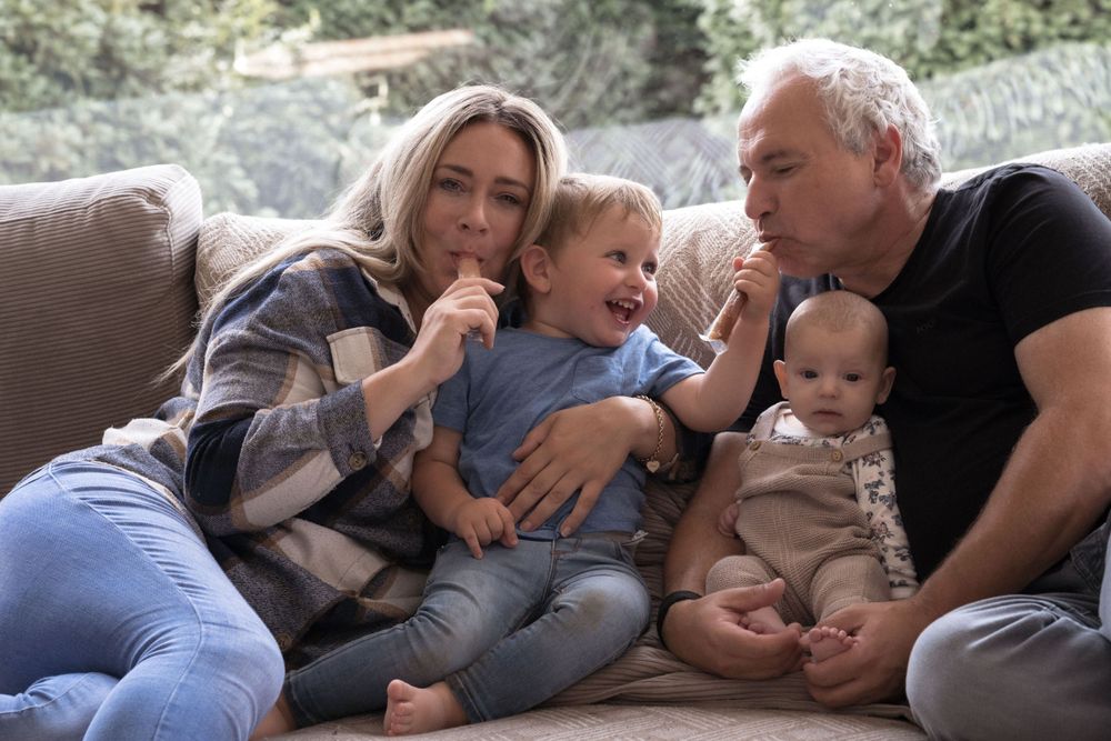 Eine fröhliche Familie erlebt unbeschwerte, verspielte Momente auf einem gemütlichen, einladenden Sofa