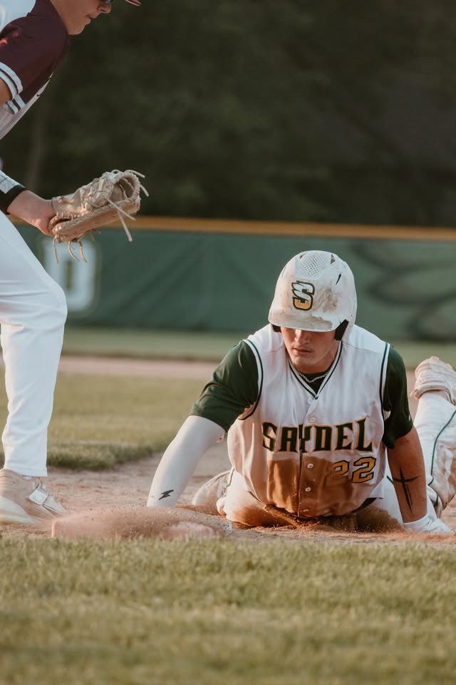 Saydel baseball player #22 sliding into base during an intense game moment.